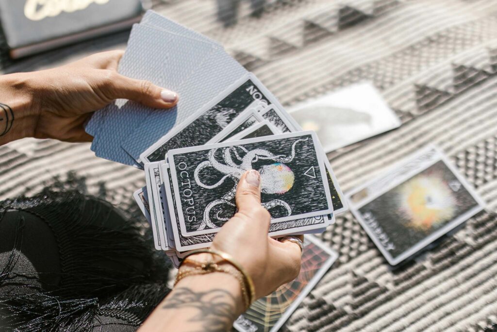 Hands holding tarot cards.