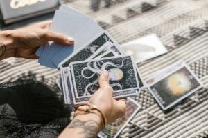 Hands holding tarot cards.